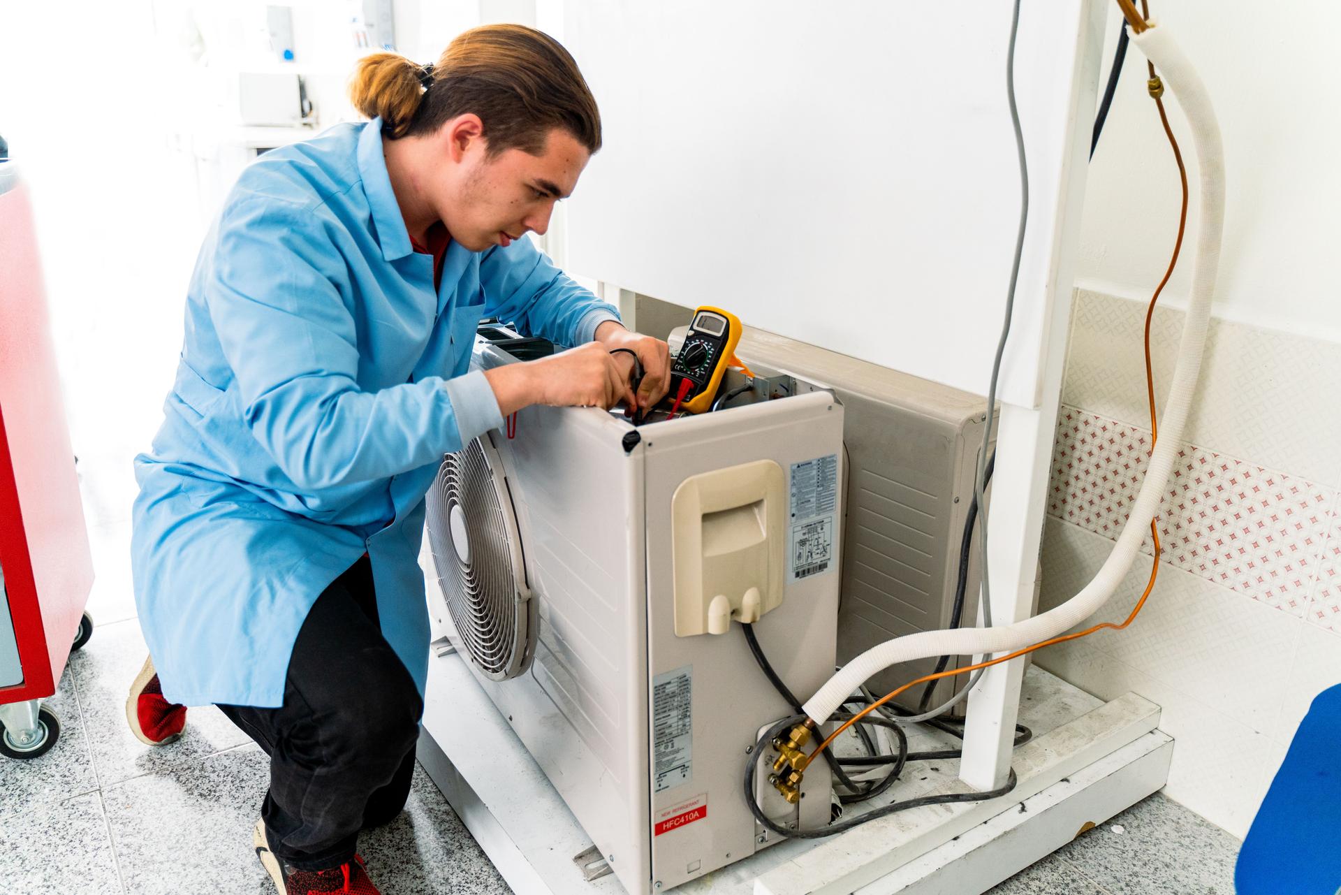 Air conditioner repairman works on home unit